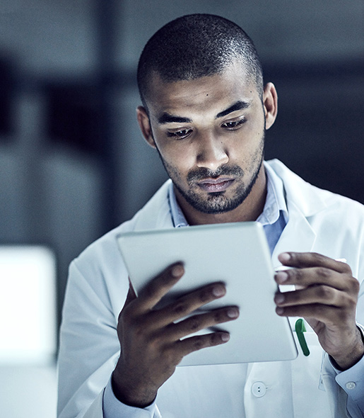 A healthcare professional examines a document on a tablet.
