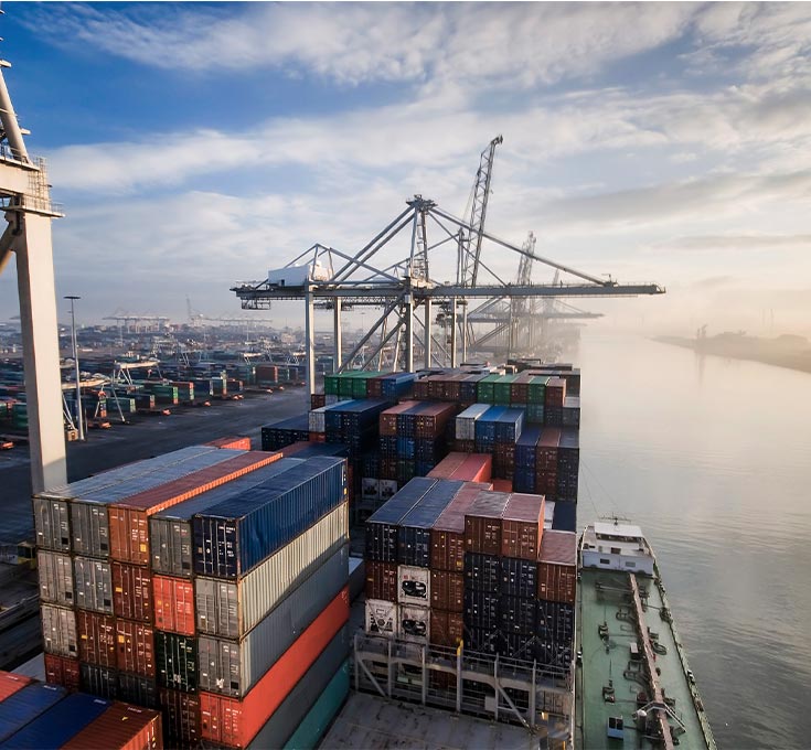 Countless shipping containers stacked high at a major shipping port.