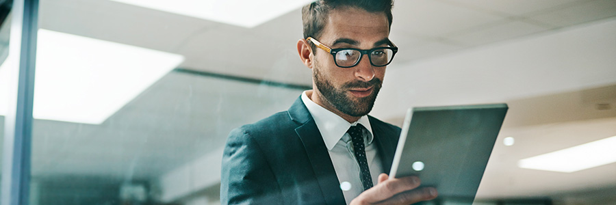 A businessperson in an office setting looking at information on a tablet computer.