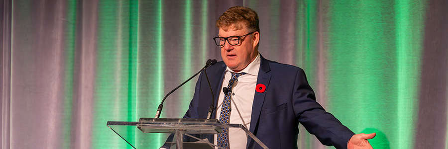 Peter Haynes speaking in front of a crowd at a conference.