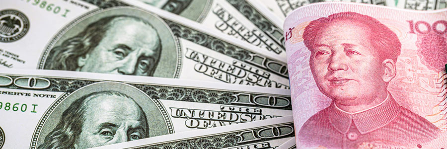 Billets en yuan pliés, posés au-dessus de plusieurs billets en dollars américains.
