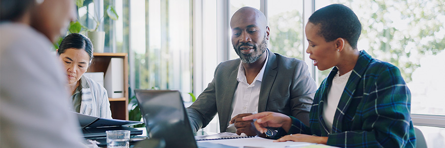 Two people working on business documents at a desk.