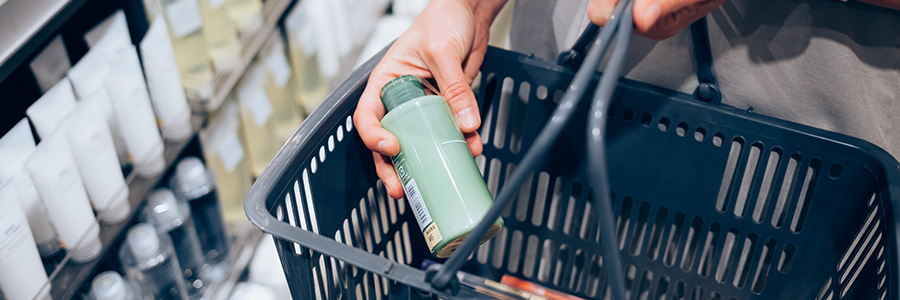 A shopper putting a beauty product in their basket to purchase.