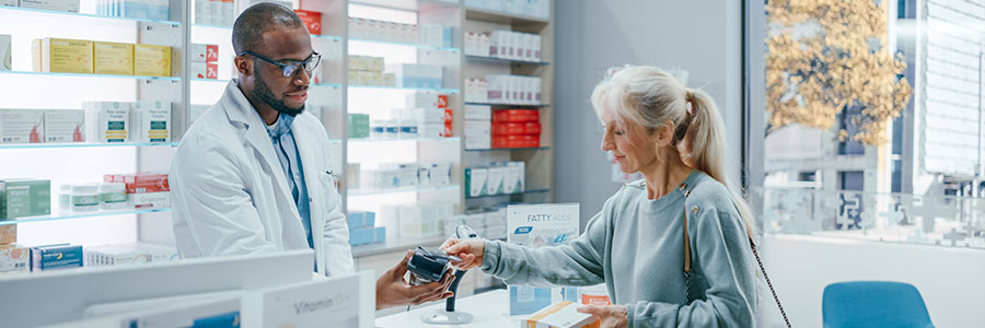 Une femme dans une pharmacie paie son ordonnance.