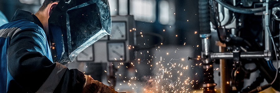 A construction worker welding a tank shut.