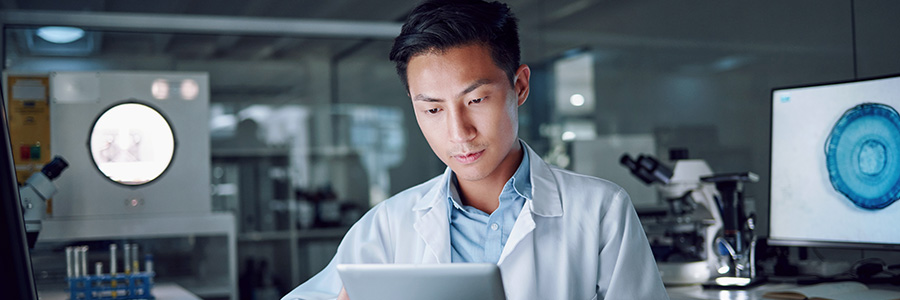 A lab technician looks at a tablet computer.