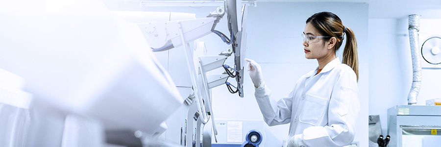 A lab technician using a touchscreen monitor in a lab setting.