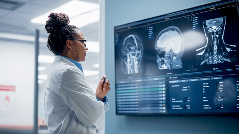 A medical professional looking at images of a person's nervous system.