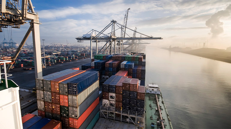 Countless shipping containers stacked high at a major shipping port.