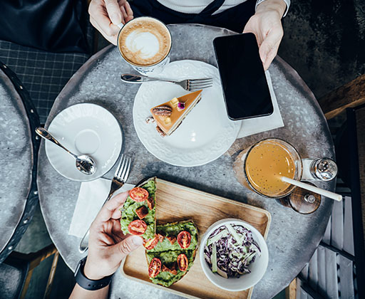  Vue de dessus d'une table de restaurant où les gens mangent des plats à la mode.