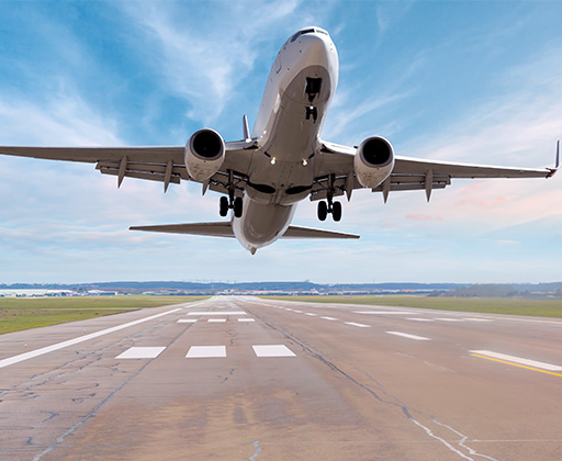 Looking up at a commerical airliner taking off from a runway.