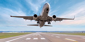 View from under a commercial passenger airplane taking off from a runway.